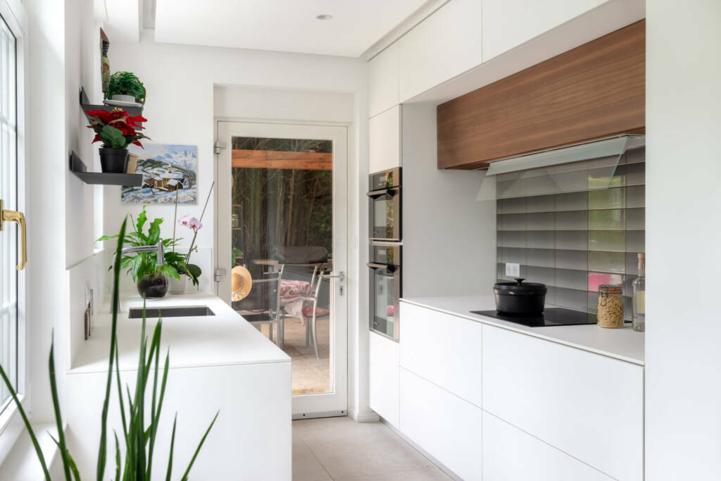 La zone cuisson de la cuisine avec une hotte finition bois et groupe aspirant, par Etymodéco, Magali Brustlein, Décoratrice et Expert Feng Shui à Saint Louis en Alsace