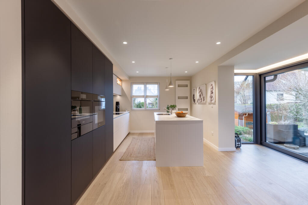 La grande cuisine avec ilot central blanc et colonne noire pour l'électro-ménager et les rangements, par Etymodéco, Magali Brustlein, Décoratrice et Expert Feng Shui à Saint Louis en Alsace