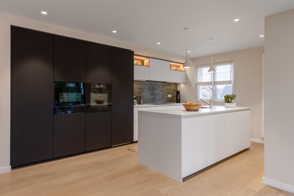 La grande cuisine avec ilot central blanc marbre et colonne noire pour l'électro-ménager, par Etymodéco, Magali Brustlein, Décoratrice et Expert Feng Shui à Saint Louis en Alsace