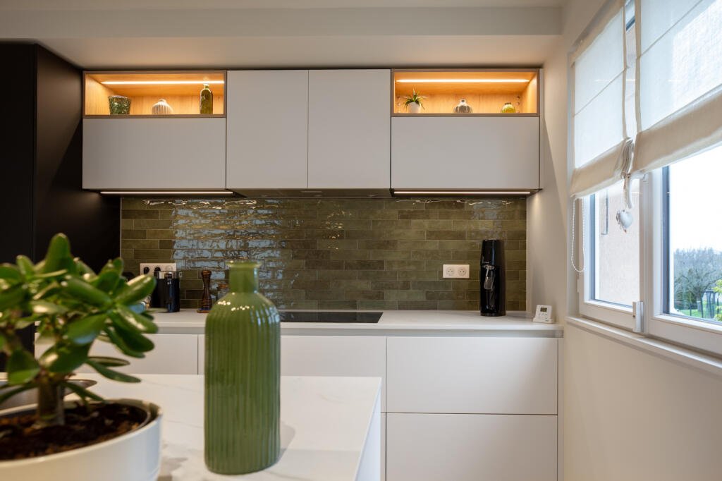 Le coin cuisson avec des émaux vert kaki et les éléments hauts et bas blanc cassé, par Etymodéco, Magali Brustlein, Décoratrice et Expert Feng Shui à Saint Louis en Alsace