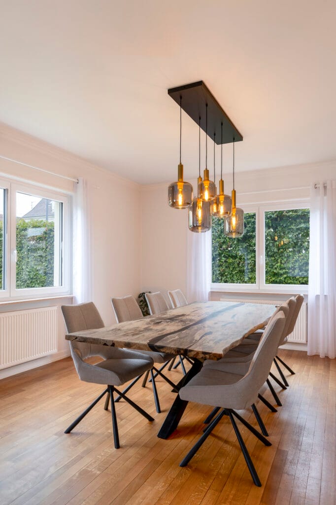 La salle à manger avec sa table en bois massif résiné et son luminaire chaleureux, par Etymodéco, Magali Brustlein, Décoratrice d'intérieur dans le Haut-Rhin