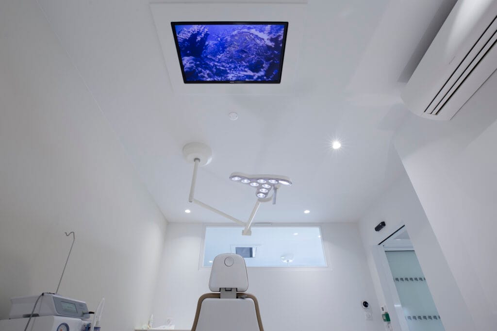 Une salle de soins avec écran intégré au plafond, par Etymodéco, Magali Brustlein, Décoratrice d'intérieur à Saint Louis en Alsace