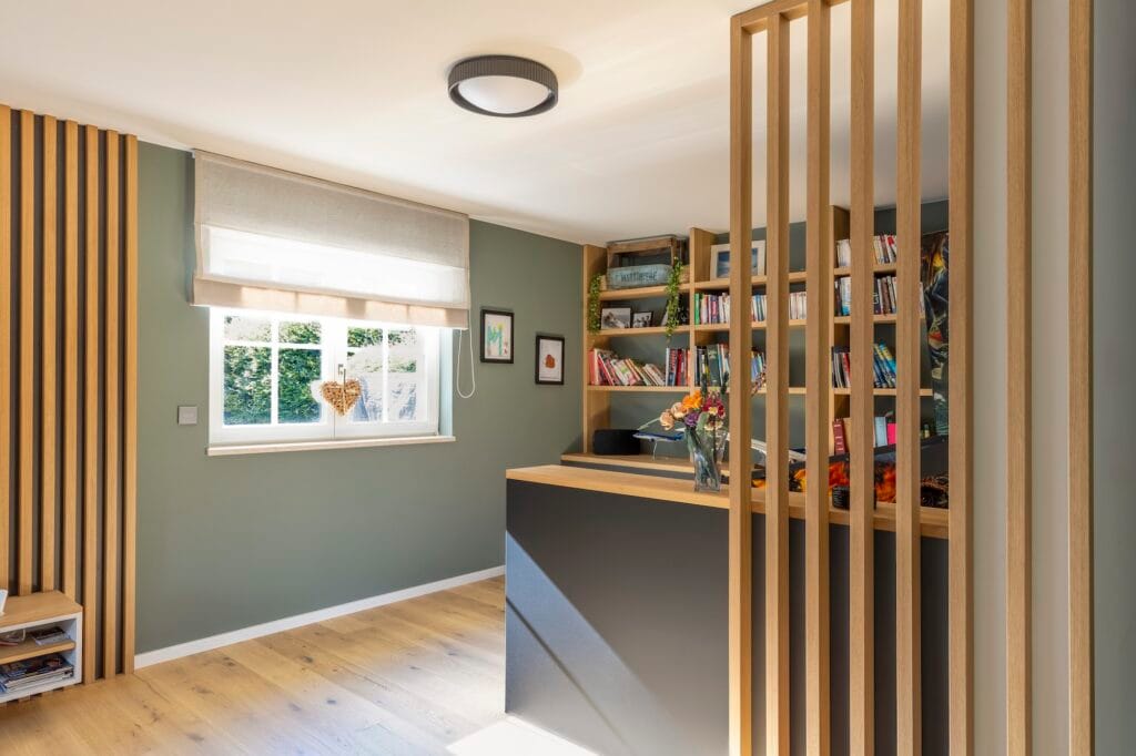 L'espace jeux et bibliothèque, couleur vert lichen et claustra bois clair, par Etymodéco, Magali Brustlein, Décoratrice d'intérieur à Saint Louis en Alsace