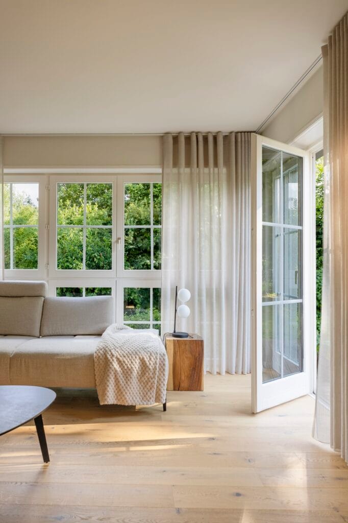 L'ouverture du salon sur le jardin, bloc de bois brut et lampe boule, par Etymodéco, Magali Brustlein, Décoratrice d'intérieur à Saint Louis en Alsace