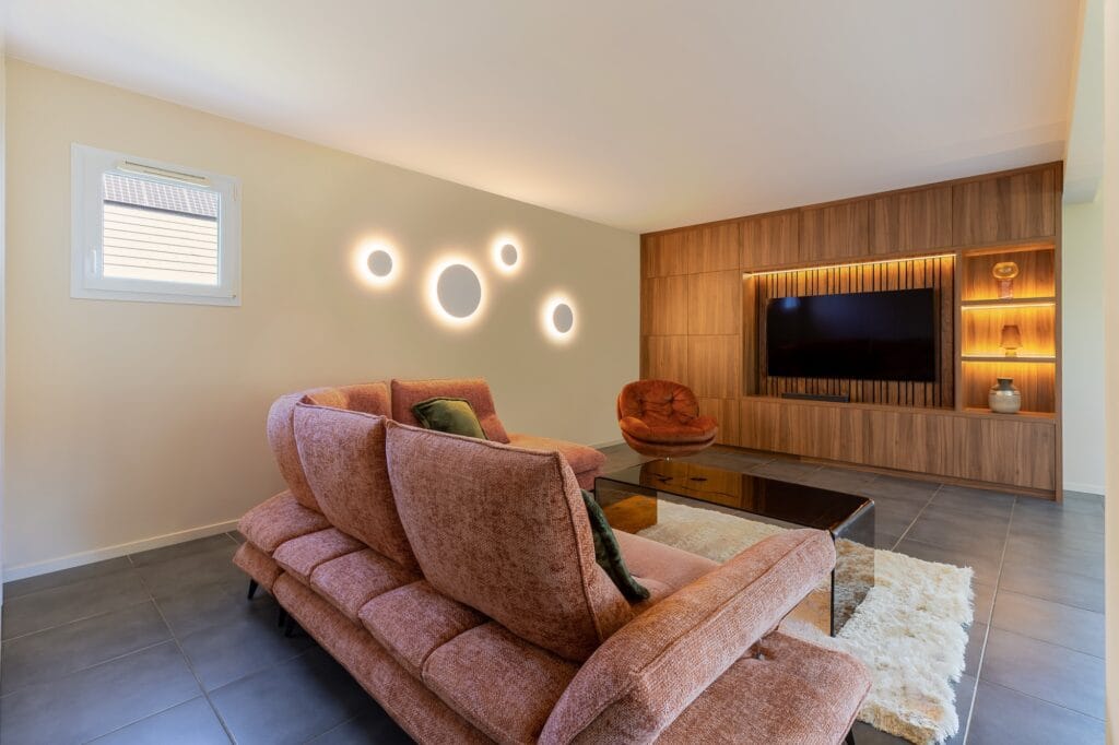Salon chaleureux avec canapé brique et meuble TV intégré, par Etymodéco, Magali Brustlein, Décoratrice d'intérieur dans le Haut-Rhin