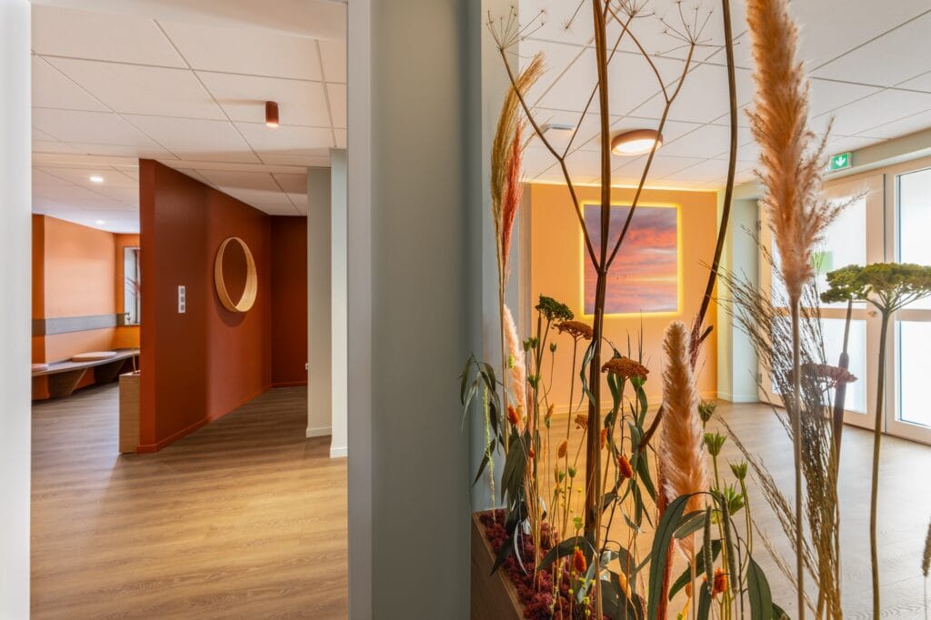 Gros plan sur arrangement floral avec vue sur la salle d'attente, par Etymodéco, Magali Brustlein, Décoratrice d'intérieur dans le Haut-Rhin