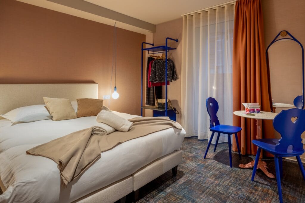 Couleurs, contrastes et uplicling pour cette chambre d'hôtel, tons orange rouille et bleu klein, par Etymodéco, Magali Brustlein, Directrice Artistique à Mulhouse en Alsace