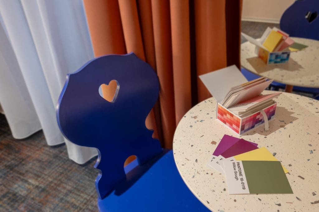 Détail des chaises alsaciennes bleu klein sur fond de tenture rouille, par Etymodéco, Magali Brustlein, Directrice Artistique à Mulhouse en Alsace